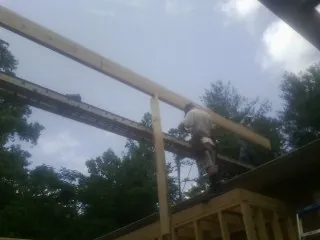 Carpenter setting a ridge beam over a new addition frame — Ice Dam Removal by Roofing Brothers in South Lyon