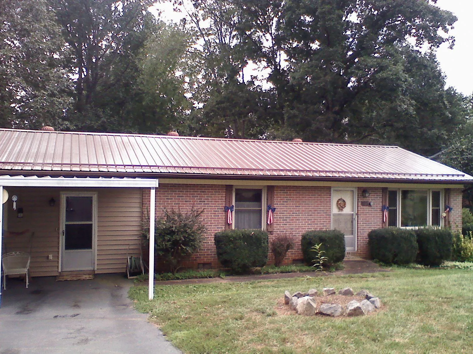 Bronze metal roof and carport on a brick ranch home — Roof Repair work by our crew in South Lyon