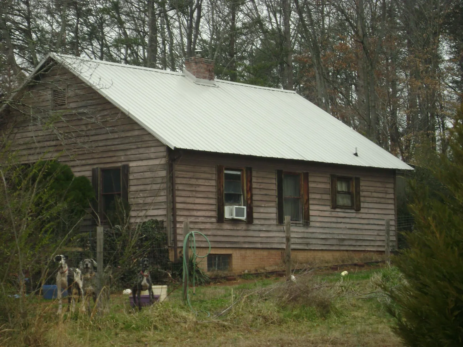 White metal roof on an old wood sided farmhouse, from a Metal Roof Installation job in South Lyon